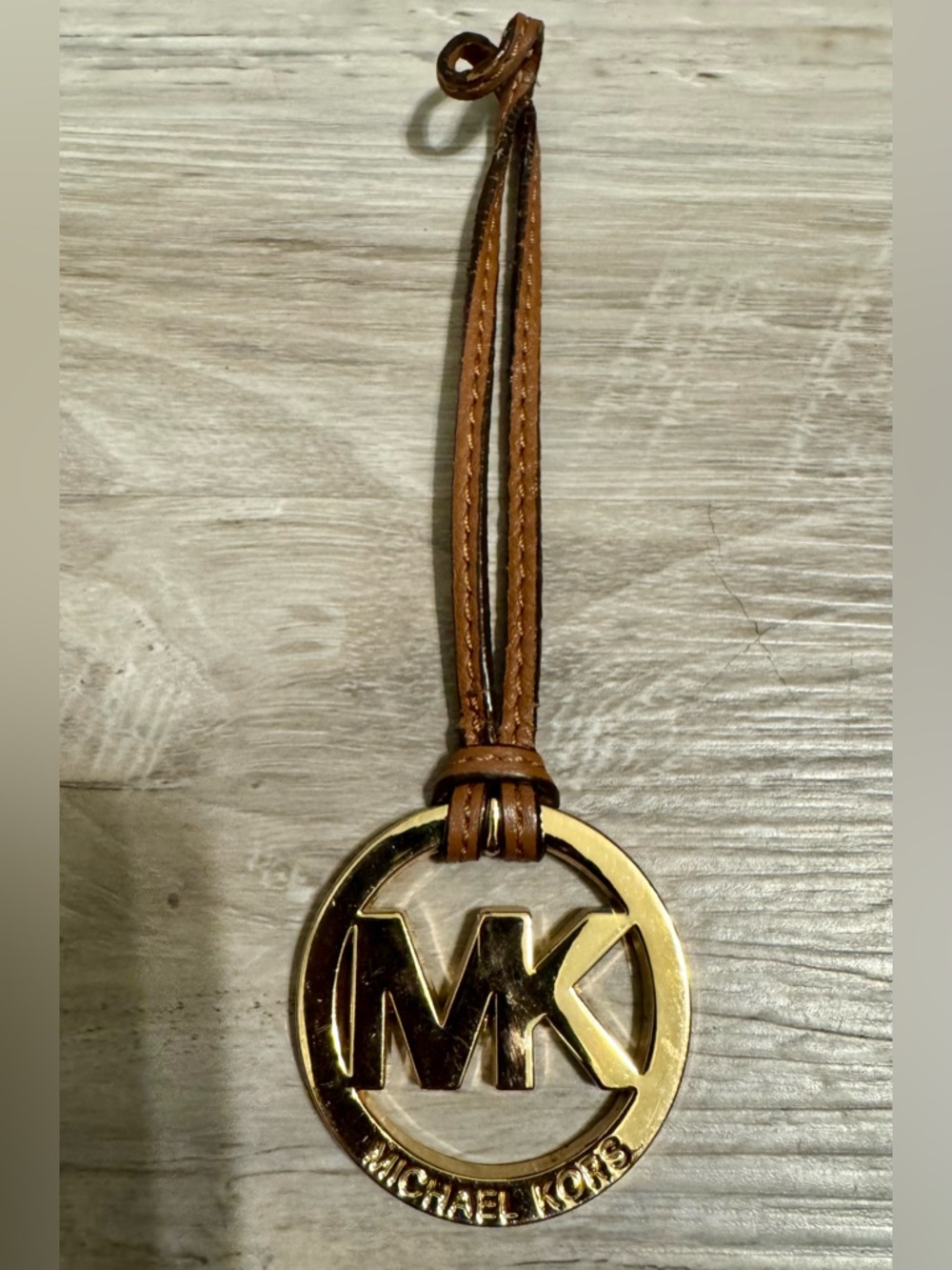 Michael Kors Logo Keychain: Gold and Brown. A gold Michael Kors logo pendant,
